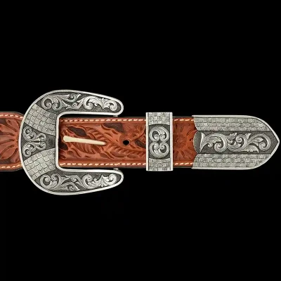 A custom western three piece belt buckle set featuring unique scrollwork and details